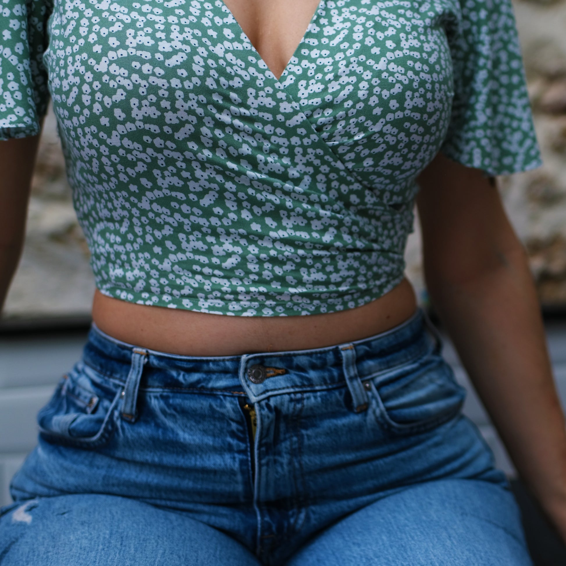 Femme assise portant un top croisé par le devant