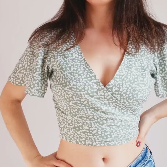 Jeune femme portant un haut fleuri croisé devant avec un joli décolleté et un noué dans le dos